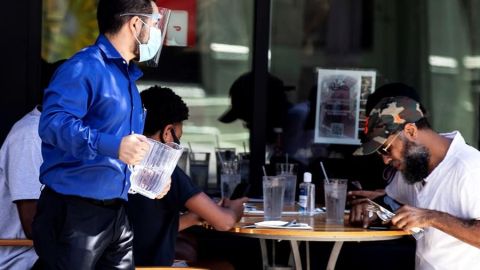 Un mesero sirve a clientes en un restaurante de Pasadena. Eso podría cambiar pronto.