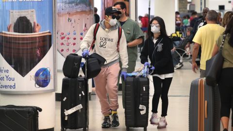 Pasajeros con mascarilla en el aeropuerto de Miami.