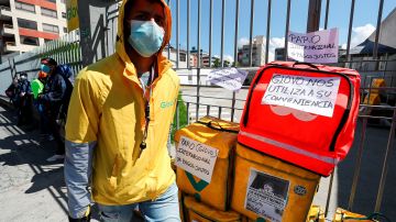 -FOTODELDÍA- AME4894. QUITO (ECUADOR), 22/04/2020.- Decenas de repartidores en motocicleta a domicillo de la cadena "Glovo" protestan hoy miércoles, en una de las calles de Quito, para reclamar un "pago justo" y mayor seguridad sanitaria para ejercer su labor, en el marco de protestas que se produjeron también en otros países. EFE/José Jácome