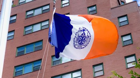 El sello de la Ciudad de Nueva York como se ve en la bandera de la Ciudad que vuela sobre un parque en Manhattan.