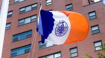 El sello de la Ciudad de Nueva York como se ve en la bandera de la Ciudad que vuela sobre un parque en Manhattan.