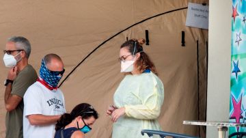 Personas con tapabocas esperan ingresar al Memorial Regional Hospital en Hollywood, Florida.
