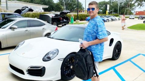 El hombre posó con el Porsche que compró con un cheque falso.