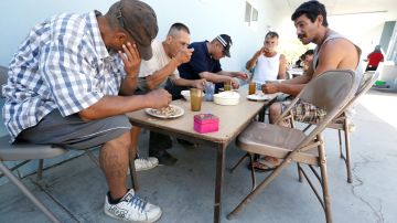 Rodolfo González Ruiz (izq.), de 48 años, quien fue deportado del Este de Los Ángeles, es uno de los cientos de deportados que cada semana reciben una comida caliente en el refugio Madre Assunta./ AURELIA VENTURA