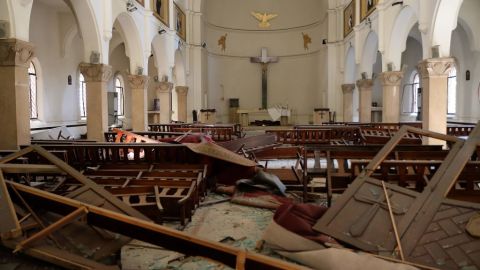 El religioso trata de refugiarse ante el desplome del techo del templo.