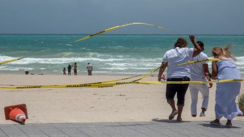 People enjoy the waves on the closed beach in Miami beach, Florida, USA, 01 August 2020. Hurricane Isaias weakened and lost intensity after passing over the Bahamas and it still on course to arrive off the coast of Florida Saturday night, according to the National Hurricane Center.