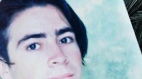 A mother holds a photo of her kidnapped son during