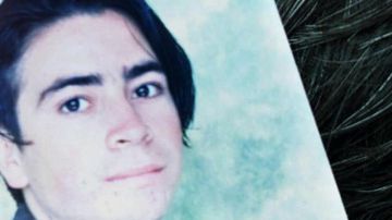 A mother holds a photo of her kidnapped son during