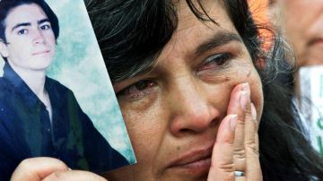 A mother holds a photo of her kidnapped son during