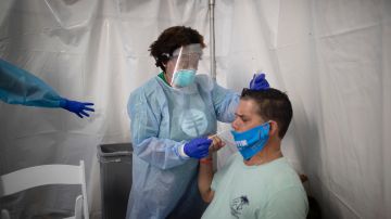 MIAMI LAKES, FLORIDA - JULY 22: Dr. Jacqueline Delmont, Chief Medical Officer of SOMOS Community Care, uses a nasal swab to test Eddie Mena for COVID-19 in a medical tent at a testing site locate at the Miami Lakes Youth Center on July 22, 2020 in Miami Lakes, Florida. Testing is being provided by doctors from New York City associated with SOMOS Community Care, as the state of Florida experiences a surge in coronavirus cases.  (Photo by Joe Raedle/Getty Images)
