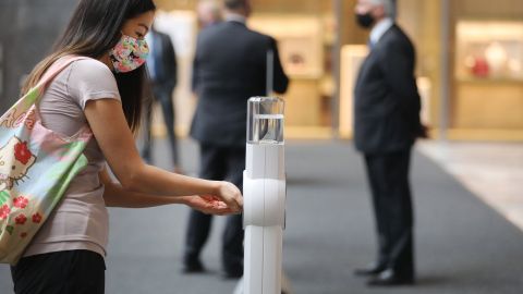 Una mujer desinfecta sus manos en el primer día de la reapertura de los centros comerciales al público en Nueva York.