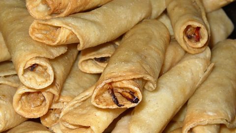 Estos tacos dorados rellenos de pollo serán ahogados en una delicosa salsa picante y decorados al servirse.