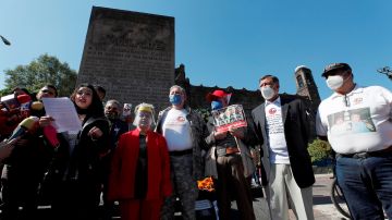 Varias personas colocan ofrendas para conmemorar la Matanzas de Tlatelolco en la Plaza de las tres Culturas.