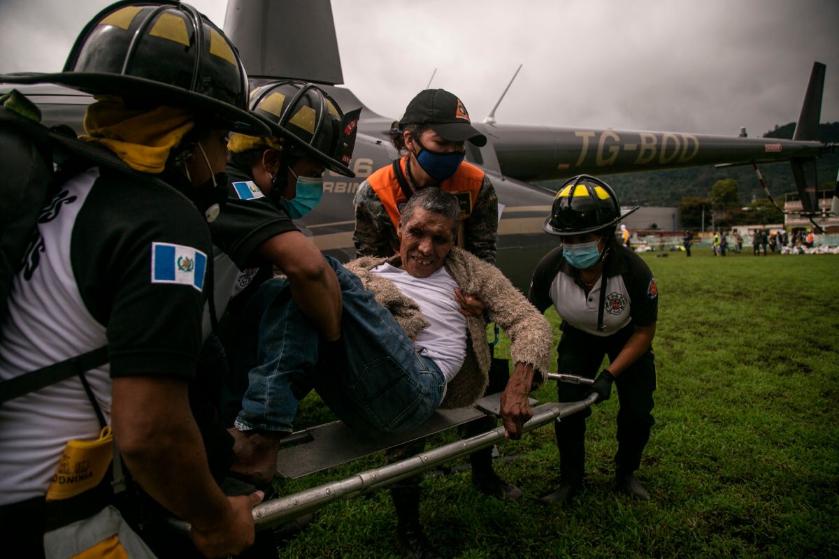 Socorristas rescatn a un herido la zona del desastre donde se estima que decenas de personas murieron por un alúd en la aldea Quejá, del departamento de Alta Verapaz.