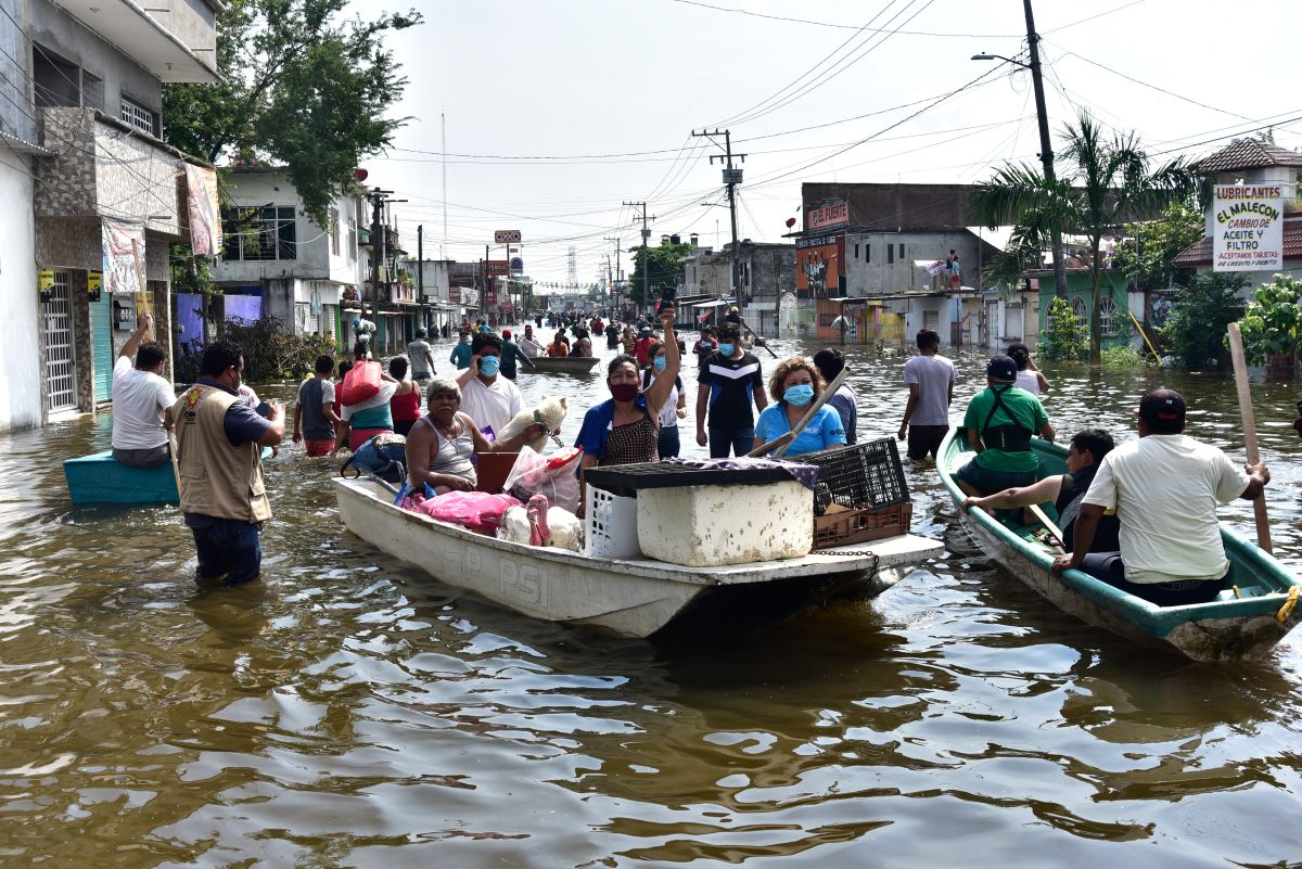 Habitantes del estado de Tabasco transitan por una avenida inundada por las intensas lluvias este lunes.