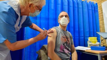 David Farrell, paciente de 51 años, recibe una de las dos vacunas de Pfizer y BioNtech en un centro de vacunación en Cardiff, Reino Unido.