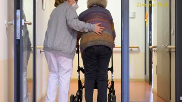 A elderly care nurse helps a resident in the retirement home St. Barbara of German welfare organisation Caritas in Stuttgart, southern Germany, on November 17, 2020, amid the new coronavirus COVID-19 pandemic. (Photo by THOMAS KIENZLE / AFP) (Photo by THOMAS KIENZLE/AFP via Getty Images)