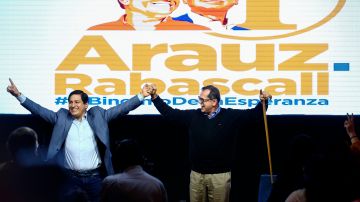 El candidato correísta Andrés Arnaúz (i) celebra junto a su compañero de fórmula Carlos Rabascall.