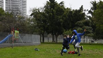 Kids play football at Las Heras park after lockdown measures to fight the COVID-19 novel coronavirus pandemic were relaxed, in Buenos Aires, on July 21, 2020. - Argentina began this week a gradual flexibilization within the pandemic lockdown by reopening activities in a phased scheme until August 3, including a limited number of industrial, commercial, service and recreational activities. (Photo by JUAN MABROMATA / AFP) (Photo by JUAN MABROMATA/AFP via Getty Images)