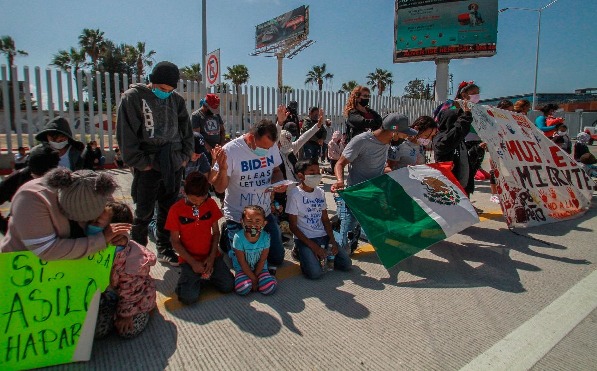 Migrantes rezan en las inmediaciones del cruce fronterizo de El Chaparral, en Tijuana (México).  