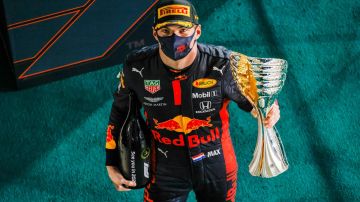 ABU DHABI, UNITED ARAB EMIRATES - DECEMBER 13: Race winner Max Verstappen of Netherlands and Red Bull Racing celebrates on the podium during the F1 Grand Prix of Abu Dhabi at Yas Marina Circuit on December 13, 2020 in Abu Dhabi, United Arab Emirates. (Photo by Peter Fox/Getty Images)