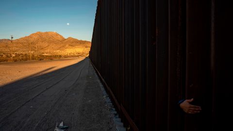 TOPSHOT - A young Mexican girl's hand is pictured on the between the metal fencing on the US-Mexico border in Anapra, New Mexico on March 19, 2019. - Speaking of an "invasion" of illegal immigrants and criminals, US President Donald Trump last week signed the first veto of his presidency, overriding congressional opposition to secure emergency funding to build a wall on the Mexican border, the signature policy of his administration. (Photo by Paul Ratje / AFP) (Photo credit should read PAUL RATJE/AFP via Getty Images)
