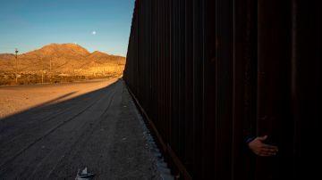 TOPSHOT - A young Mexican girl's hand is pictured on the between the metal fencing on the US-Mexico border in Anapra, New Mexico on March 19, 2019. - Speaking of an "invasion" of illegal immigrants and criminals, US President Donald Trump last week signed the first veto of his presidency, overriding congressional opposition to secure emergency funding to build a wall on the Mexican border, the signature policy of his administration. (Photo by Paul Ratje / AFP)        (Photo credit should read PAUL RATJE/AFP via Getty Images)