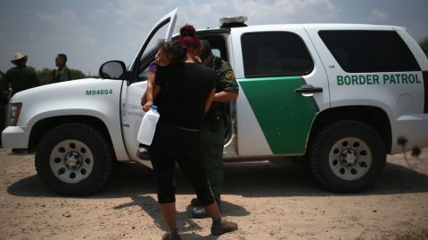 MISSION, TX - JULY 24:  A mother and child, 3, from El Salvador await transport by the U.S. Border Patrol to a processing center for undocumented immigrants after they crossed the Rio Grande into the United States on July 24, 2014 in Mission, Texas. Tens of thousands of immigrant families and unaccompanied minors have crossed illegally into the United States this year and presented themselves to federal agents, causing a humanitarian crisis on the U.S.-Mexico border.  (Photo by John Moore/Getty Images)