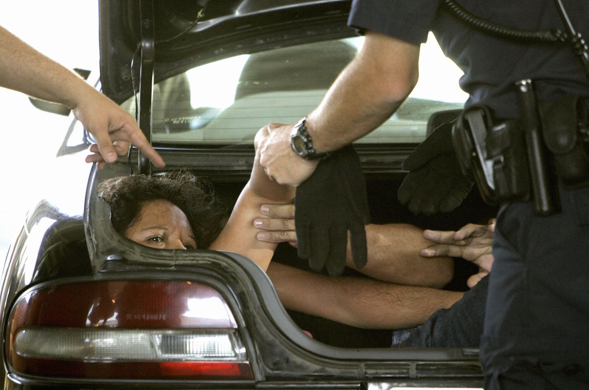 Las autoridades migratorias intervienen con una inmigrante indocumentada en el maletero de un auto en San Ysidro, California.
