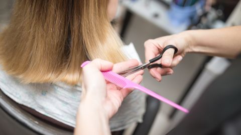 Maestra corta el pelo de niña