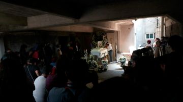 MEX1079. CIUDAD DE MÉXICO (MÉXICO), 05/05/2021.- Marisol Tapia (c), mamá del niño Brandon Giovanny, quien murió en el colapso de la Línea 12 del Metro, llora en el ataúd de su pequeño hijo en su humilde casa de Ciudad de México (México). Operarios y peritos del Gobierno de Ciudad de México intensificaron este miércoles las labores para levantar los escombros del puente de la línea 12 del metro derrumbado el lunes mientras una mayoría de mexicanos opina que la tragedia se debió a una grave negligencia. EFE/ Carlos Ramírez