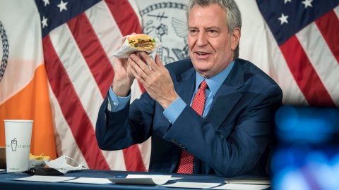 De Blasio comiendo una hamburguesa durante una rueda de prensa en 2021.