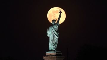 May's full Moon, known as the Full Flower Moon, and the last of the year, rises behind the Statue of Liberty on May 7, 2020 in New York City. (Photo by Johannes EISELE / AFP) (Photo by JOHANNES EISELE/AFP via Getty Images)