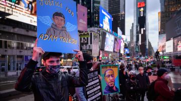 A person holds an image of 13-year-old Adam Toledo (L), who was shot and killed by police, as protesters and activists attend a vigil for Daunte Wright and others killed during police confrontations, at Times Square in New York city on April 16, 2021. - The police officer who shot dead Black 20-year-old Daunte Wright in a Minneapolis suburb after appearing to mistake her gun for her Taser was arrested on April 14 on manslaughter charges. (Photo by Ed JONES / AFP) (Photo by ED JONES/AFP via Getty Images)