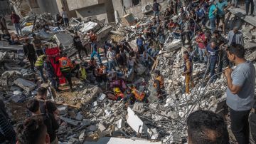 GAZA CITY, GAZA - MAY 16: Palestinian civil defense men search for people in the rubble of a destroyed building after an Israeli air strike in Gaza City on May 16, 2021 in Gaza City, Gaza. More than 140 people in Gaza and ten people in Israel have been killed as cross-border rocket exchanges continue into their seventh day with Israel vowing to continue the bombing campaign despite increasing calls from the international community to end the conflict. The conflict which erupted May 10, comes after weeks of rising Israeli-Palestinian tension in East Jerusalem, which peaked with violent clashes inside the holy site of Al-Aqsa Mosque. (Photo by Fatima Shbair/Getty Images)