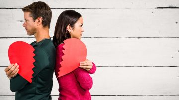 Angry,Couple,Holding,Broken,Heart,Against,Wooden,Background