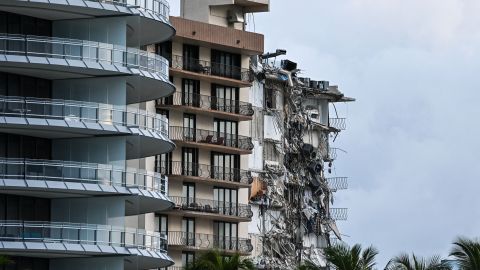 Rubble hangs from a partially collapsed building in Surfside north of Miami Beach, on June 24, 2021. - The multi-story apartment block in Florida partially collapsed early June 24, sparking a major emergency response. Surfside Mayor Charles Burkett told NBCs Today show: My police chief has told me that we transported two people to the hospital this morning at least and one has died. We treated ten people on the site. (Photo by CHANDAN KHANNA / AFP) (Photo by CHANDAN KHANNA/AFP via Getty Images)