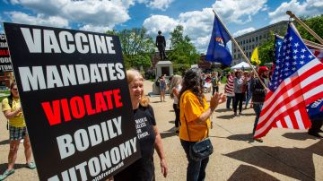 Rally goers hold signs protesting vaccines at the "World Wide Rally for Freedom", an anti-mask and anti-vaccine rally, at the State House in Concord, New Hampshire, May 15, 2021. (Photo by Joseph Prezioso / AFP) (Photo by JOSEPH PREZIOSO/AFP via Getty Images)