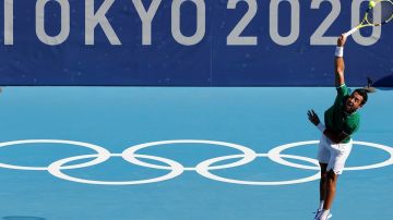 El tenista boliviano Hugo Dellien sirve la bola contra el serbio Novak Djokovic en su encuentro de primera ronda de tenis durante los Juegos Olímpicos 2020.
