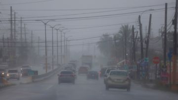 Carros por la Carretera 2 en Vega Alta, Puerto Rico, este martes en medio del impacto de Fred.