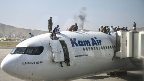 Afganos esperan en un avión en el aeropuerto de Kabul.