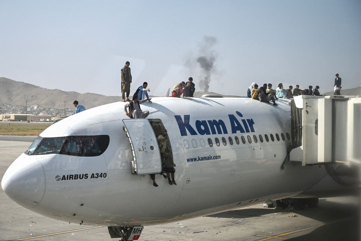 Afganos esperan en un avión en el aeropuerto de Kabul.