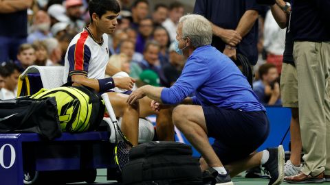 Carlos Alcaraz habla con el médico durante el segundo set de su partido contra Felix Auger-Aliassime.