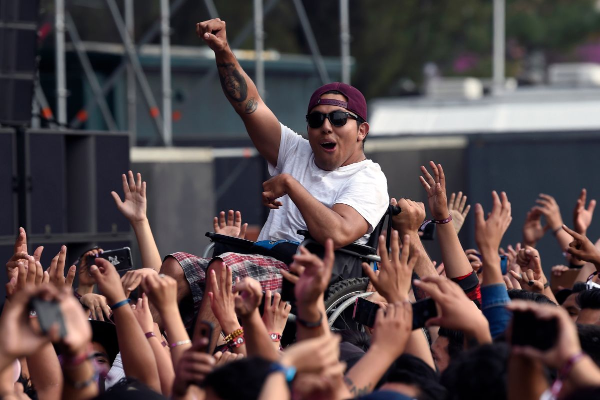 Un hombre en silla de ruedas es levantado por la multitud mientras vitorean al ritmo de la banda mexicana El Gran Silencio durante el segundo día del festival de música "Vive Latino" en la Ciudad de México.