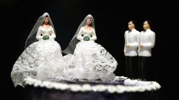 A wedding cake featuring two grooms and