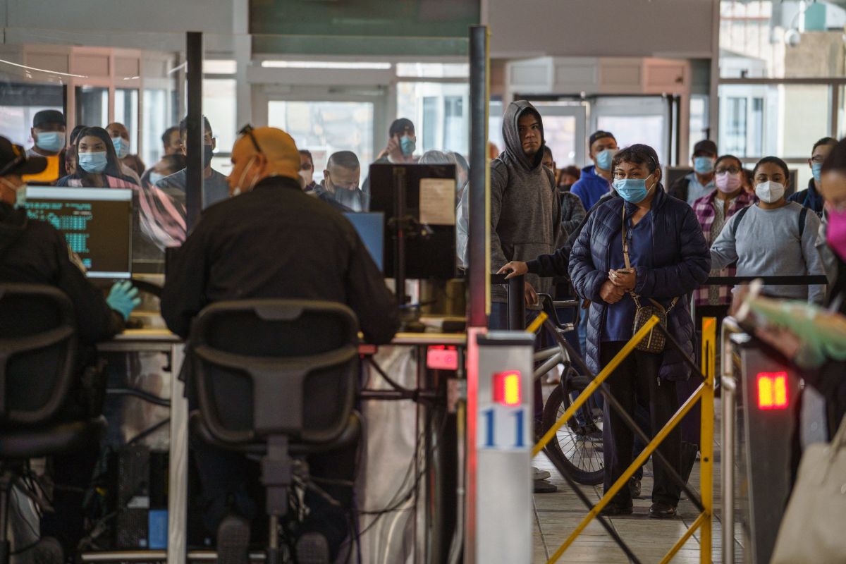 Extranjeros esperan en el puerto de El Paso, Texas, para ser revisados por oficiales migratorios.
