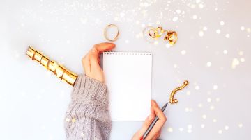 Woman,Hands,Holding,Clear,White,Notebook,,Golden,Sparkles,,New,Year,