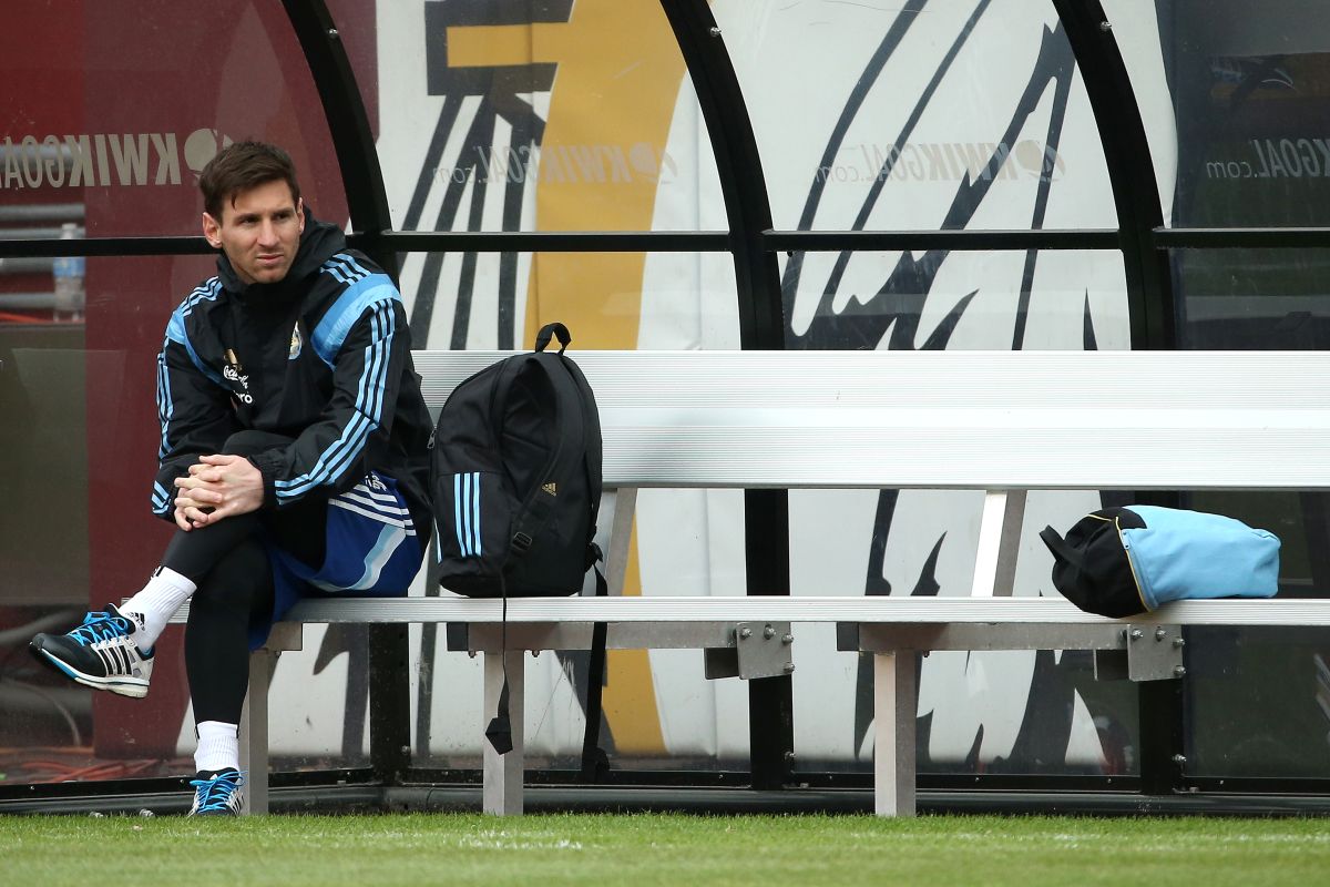 Leo Messi espera sentado en el banquillo previo a un entrenamiento con la selección Argentina.