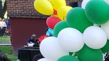 De Los Santos (centro) con miembros de la comunidad en el vecindario de Dyckman.