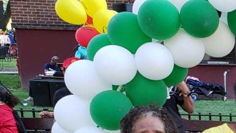 De Los Santos (centro) con miembros de la comunidad en el vecindario de Dyckman.